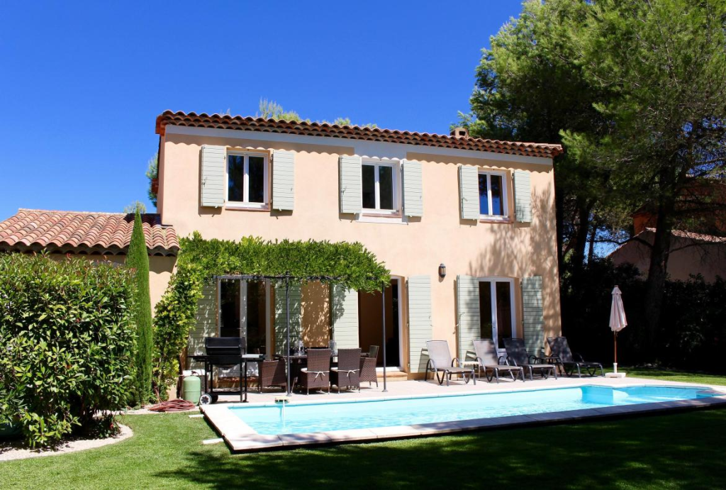 A traditional Provencal villa overlooks a private pool in a shaded garden on the Pont Royal Golf and Country Club in Provence, France.
