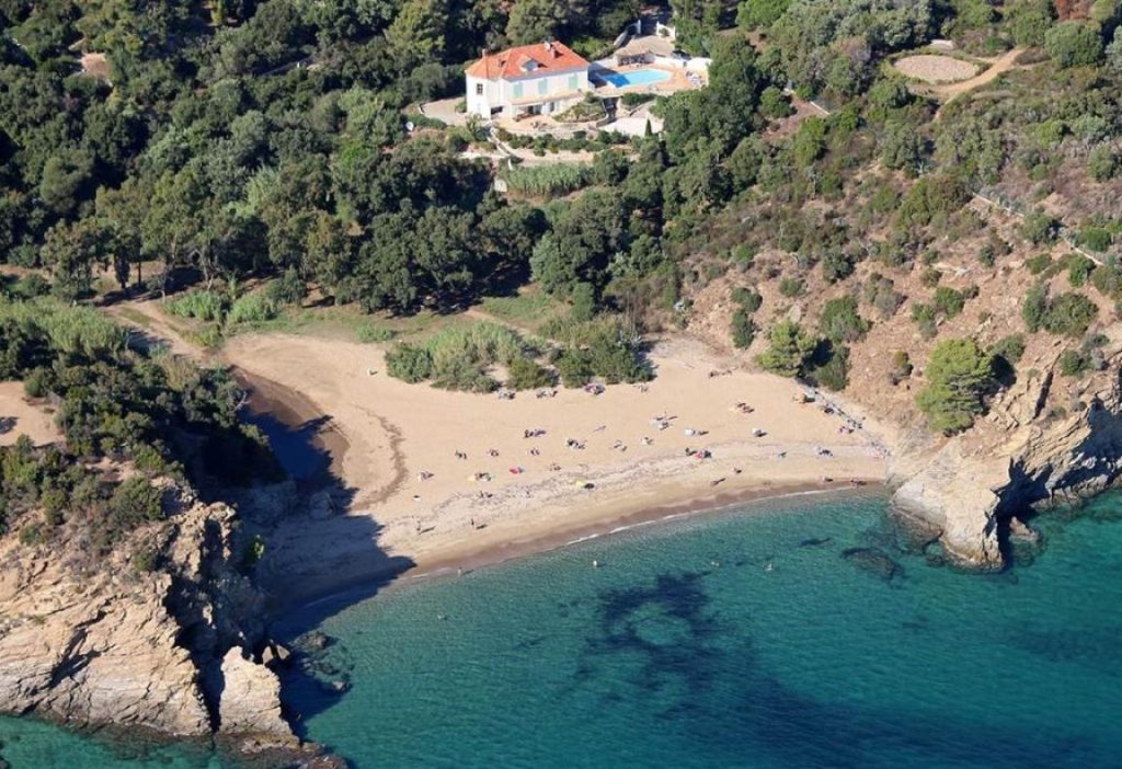 Looking up from the clear-blue water in the bay to a stunning Mediterranean holiday home with private terraces