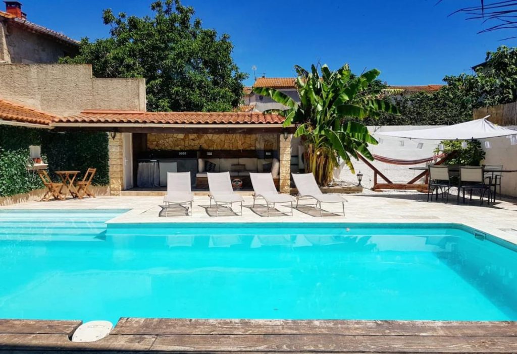 The pool and terrace with shaded area of a stunning Mediterranean holiday home near Beziers