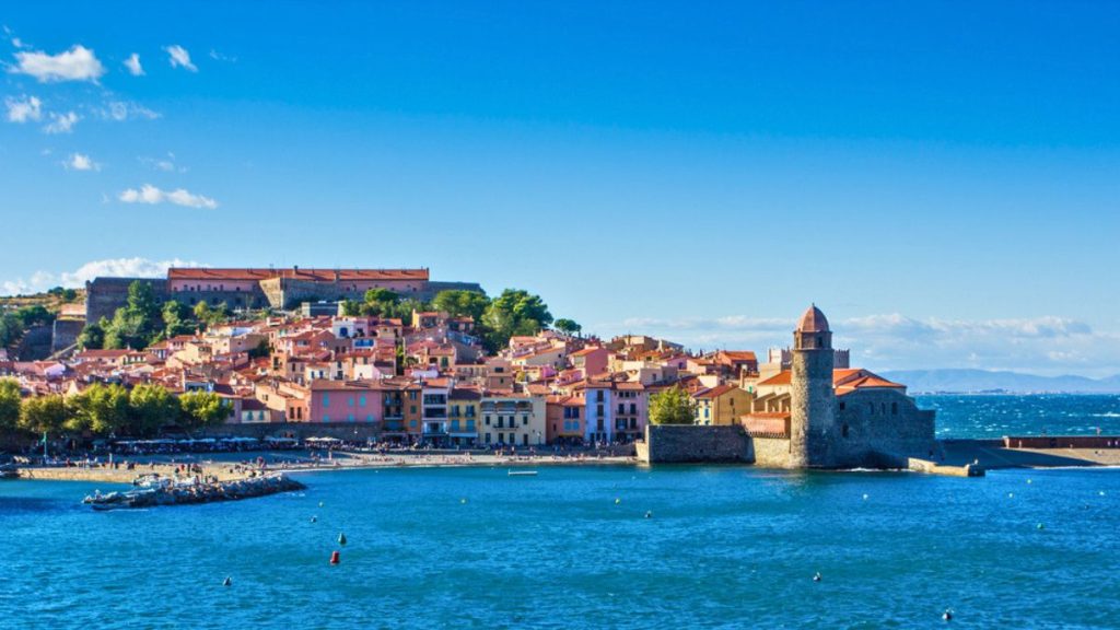 View on charming Collioure with famous lighthouse pebble beach and colorfoul houses